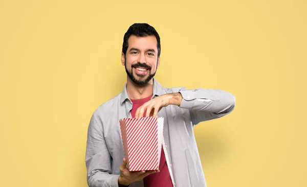 Knappe Man Met Baard Die Popcorn Eet Geïsoleerde Gele Achtergrond — Stockfoto