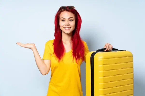 Viaggiatore Ragazza Possesso Una Valigia Isolata Sfondo Blu Tenendo Copyspace — Foto Stock