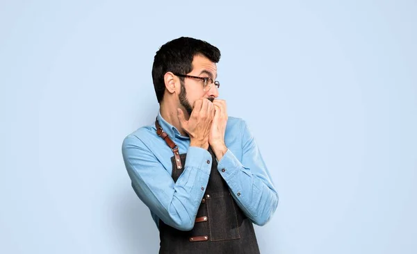 Man Apron Nervous Scared Putting Hands Mouth Isolated Blue Background — Stock Photo, Image