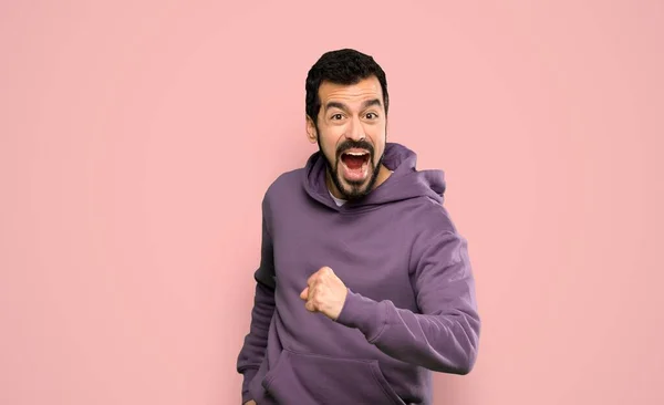 Knappe Man Met Sweatshirt Loopt Snel Geïsoleerde Roze Achtergrond — Stockfoto