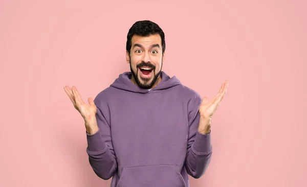 Knappe Man Met Sweatshirt Met Geschokte Gezichtsuitdrukking Geïsoleerde Roze Achtergrond — Stockfoto