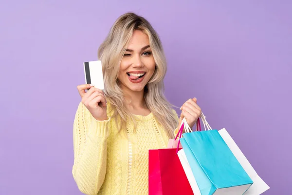 Tiener Blond Meisje Geïsoleerde Paarse Achtergrond Holding Shopping Tassen Een — Stockfoto