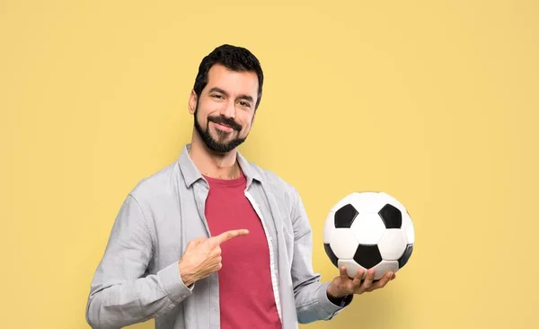 Knappe Man Met Baard Die Een Voetbal Geïsoleerde Gele Achtergrond — Stockfoto