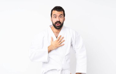 Karate yapan genç adam beyaz arka plan üzerinde şaşırmış ve şaşırmış görünüyor.