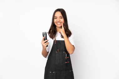 Beyaz arka planda izole edilmiş genç kuaför kadın mutlu ve hoş bir ifadeyle gülümsüyor.