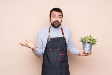 Bir bitkiyi izole edilmiş arka planda tutan adam şüpheli hareketler yapıyor.