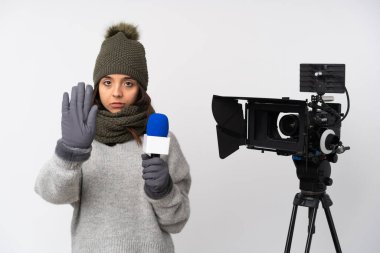 Muhabir kadın mikrofon tutuyor ve izole edilmiş beyaz arka plandan haber veriyor.