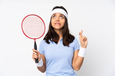 Genç badminton oyuncusu kadın izole edilmiş beyaz arka planda parmakları çapraz ve en iyisini diliyor.