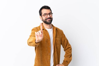 Beyaz arka planda kadife ceket giyen beyaz saçlı, sakallı yakışıklı bir adam parmak kaldırıyor.