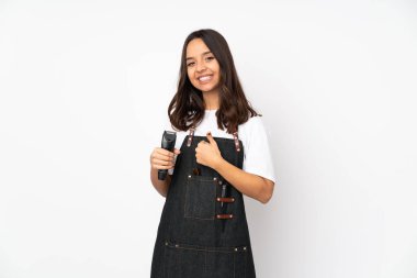 Beyaz arka planda izole edilmiş genç bir kuaför kadın baş parmak hareketi yapıyor.