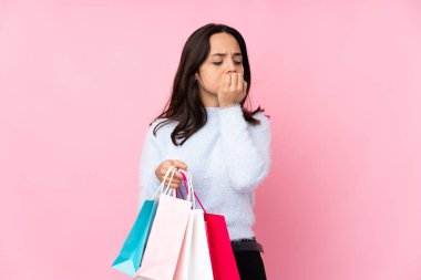 Soyutlanmış pembe arka planda alışveriş çantasıyla genç bir kadının şüpheleri var