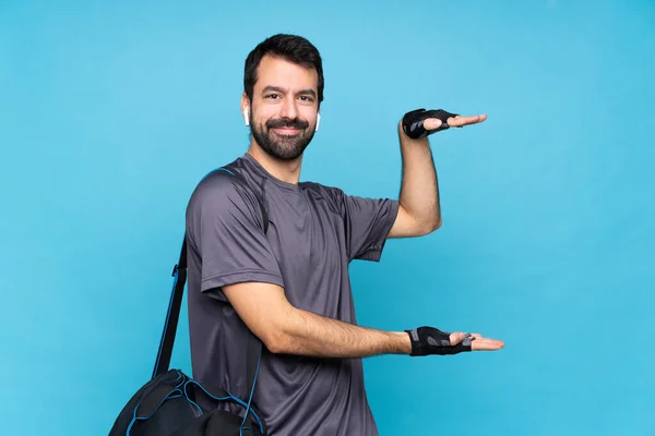 Joven Deportista Con Barba Sobre Fondo Azul Aislado Sosteniendo Espacio — Foto de Stock