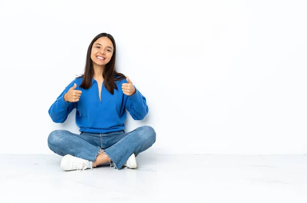 Jovem Mista Mulher Sentada Chão Isolado Fundo Branco Dando Gesto — Fotografia de Stock