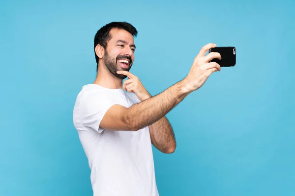 Junger Mann Mit Bart Vor Blauem Hintergrund Macht Ein Selfie — Stockfoto