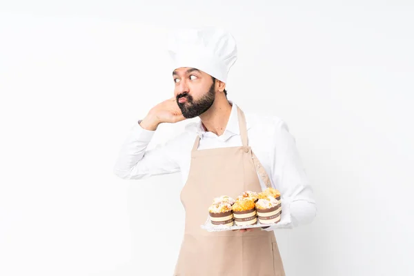 Jeune Homme Tenant Gâteau Muffin Sur Fond Blanc Isolé Écoutant — Photo