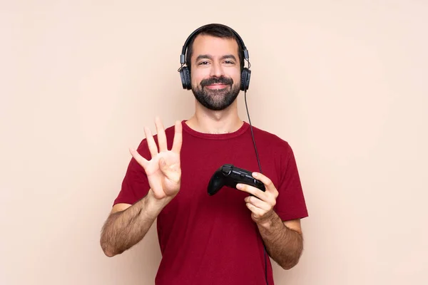 Mann Spielt Mit Videospielsteuerung Über Isolierte Wand Glücklich Und Zählt — Stockfoto