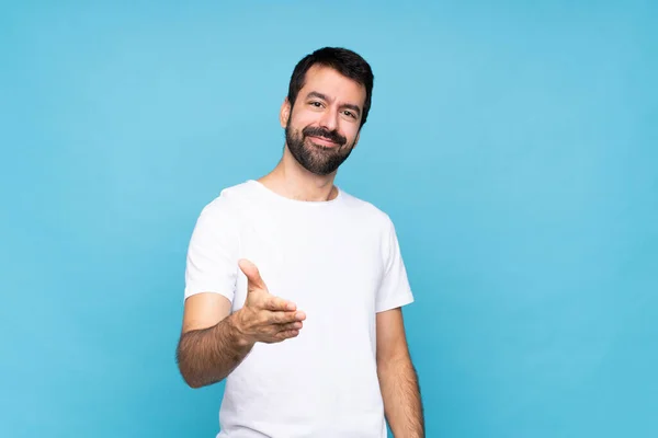 Jongeman Met Baard Geïsoleerde Blauwe Achtergrond Schudden Handen Voor Het — Stockfoto