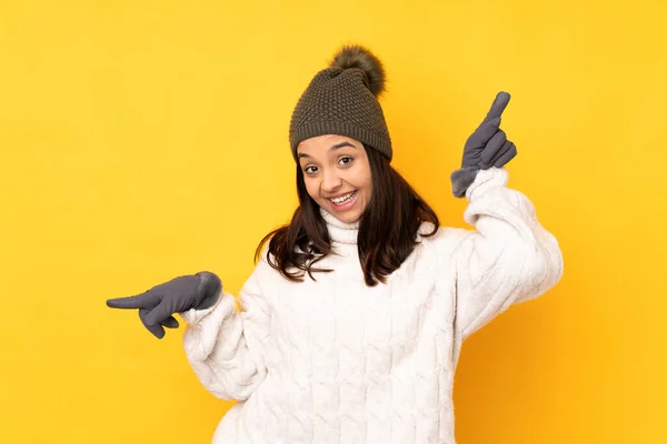 Young Woman Winter Hat Isolated Yellow Background Pointing Finger Laterals — Stock Photo, Image