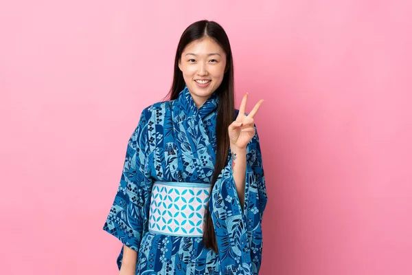 Joven Chica China Usando Kimono Sobre Fondo Aislado Sonriendo Mostrando —  Fotos de Stock