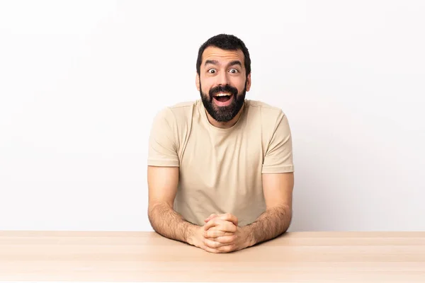 Blanke Man Met Baard Een Tafel Met Verrassende Gezichtsuitdrukking — Stockfoto