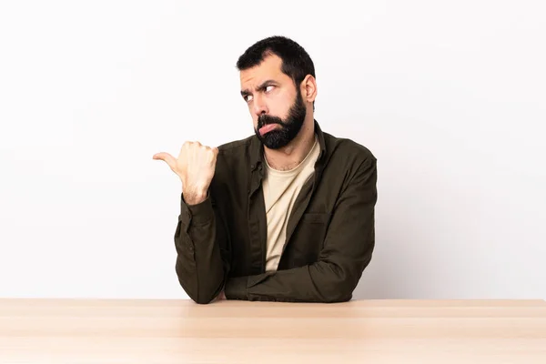Caucasian Man Beard Table Unhappy Pointing Side — Stock Photo, Image