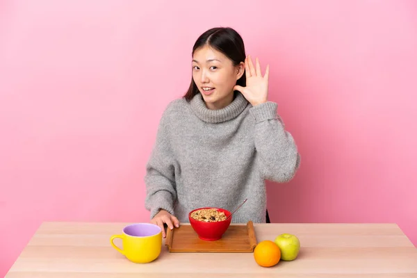 Junges Chinesisches Mädchen Frühstückt Einem Tisch Und Hört Etwas Indem — Stockfoto