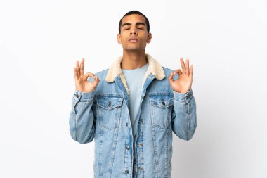 Zen pozunda izole edilmiş beyaz arka planı olan Afrikalı Amerikalı bir adam.