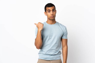 Afro-Amerikalı adam izole edilmiş beyaz arka planda mutsuz ve kenarı işaret ediyor.
