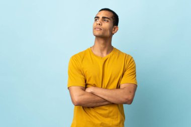 Afrikalı Amerikalı bir adam izole edilmiş arka planda yan tarafa bakıyor.