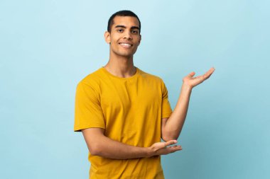 Afrikalı Amerikalı adam izole edilmiş arka planda. Davet etmek için ellerini yana uzatıyor.