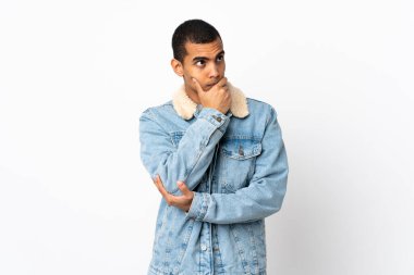 Afro-Amerikalı bir adam, izole edilmiş beyaz arka planda kuşkuları ve kafa karıştırıcı yüz ifadesi var.