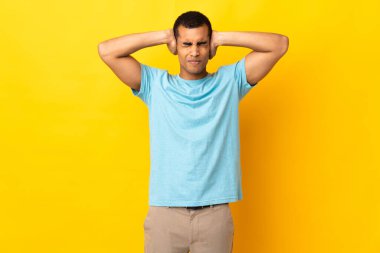 İzole edilmiş arka planda kalan Afrikalı Amerikalı adam hayal kırıklığına uğramış ve kulaklarını kapatmış