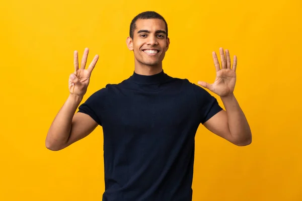 African American Man Räkna Domningar Över Isolerad Gul Bakgrund — Stockfoto