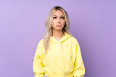 İzole edilmiş mor arka planda sarı bir kazak giyen genç kız...