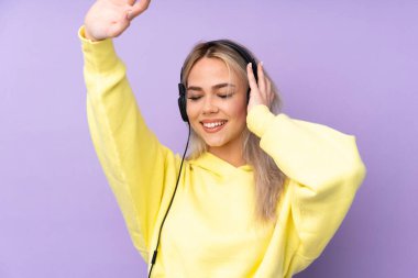 Soyutlanmış mor arka planda müzik ve dans dinleyen genç kız.