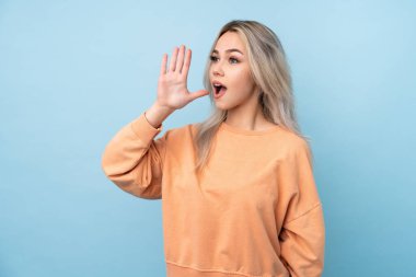 Soyutlanmış mavi arka planda genç bir kız ağzı açık bağırıyor.