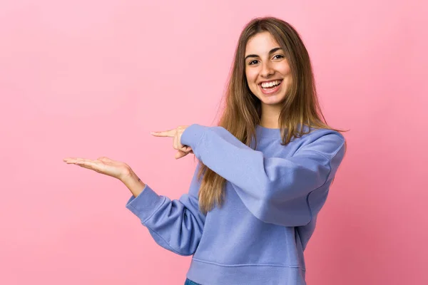 Jovem Mulher Sobre Fundo Rosa Isolado Segurando Copyspace Imaginário Palma — Fotografia de Stock