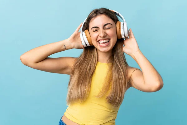 Soyutlanmış Mavi Arka Planda Müzik Dinleyen Genç Bir Kadın — Stok fotoğraf