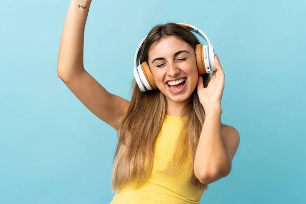 Mujer Joven Sobre Fondo Azul Aislado Escuchando Música Bailando —  Fotos de Stock