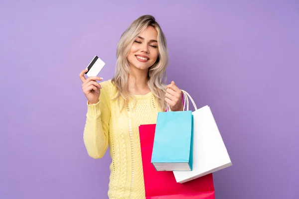 Adolescente Rubia Chica Sobre Aislado Púrpura Fondo Sosteniendo Bolsas Compras —  Fotos de Stock