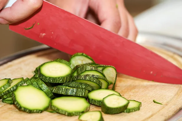 Fresh green zucchini sliced by chef on a chopping board
