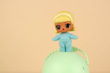 Masada renkli plastik Lol bebeği ve oyuncak kutusu var. Mga Entertainment tarafından üretilen Lol Sürpriz serisi oyuncakları..