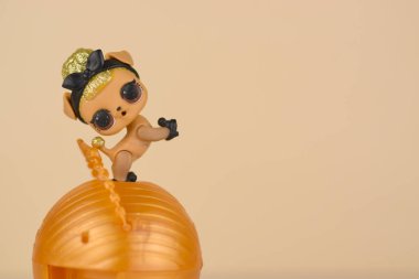 Masada renkli plastik Lol bebeği ve oyuncak kutusu var. Mga Entertainment tarafından üretilen Lol Sürpriz serisi oyuncakları..