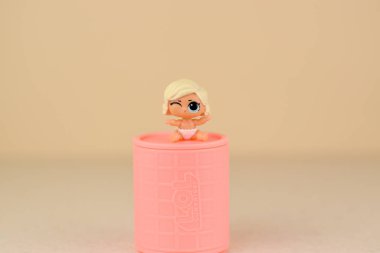 Masada renkli plastik Lol bebeği ve oyuncak kutusu var. Mga Entertainment tarafından üretilen Lol Sürpriz serisi oyuncakları..