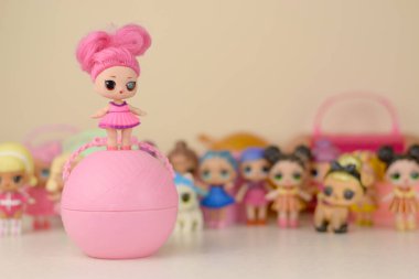 Masada bir sürü renkli plastik lolipop bebekleri var. Mga Entertainment tarafından üretilen Lol Sürpriz serisi oyuncakları..