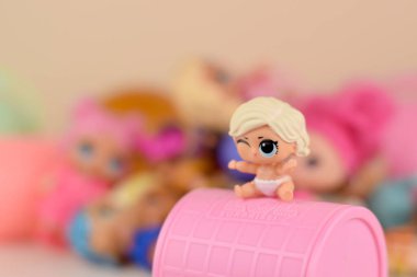 Masada bir sürü renkli plastik lolipop bebekleri var. Mga Entertainment tarafından üretilen Lol Sürpriz serisi oyuncakları..