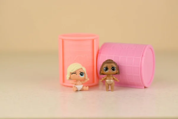 Zwei bunte Plastik-Lol-Puppen und Spielzeugbehälter auf dem Tisch. lol surprise series toys hergestellt von mga entertainment inc. — Stockfoto