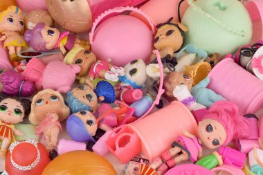 Masada bir sürü renkli plastik lolipop bebekleri var. Mga Entertainment tarafından üretilen Lol Sürpriz serisi oyuncakları..