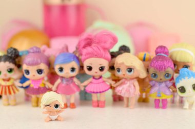 Masada bir sürü renkli plastik lolipop bebekleri var. Mga Entertainment tarafından üretilen Lol Sürpriz serisi oyuncakları..