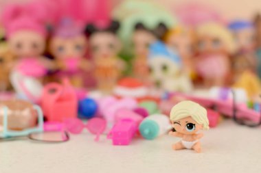 Masada bir sürü renkli plastik lolipop bebekleri var. Mga Entertainment tarafından üretilen Lol Sürpriz serisi oyuncakları..